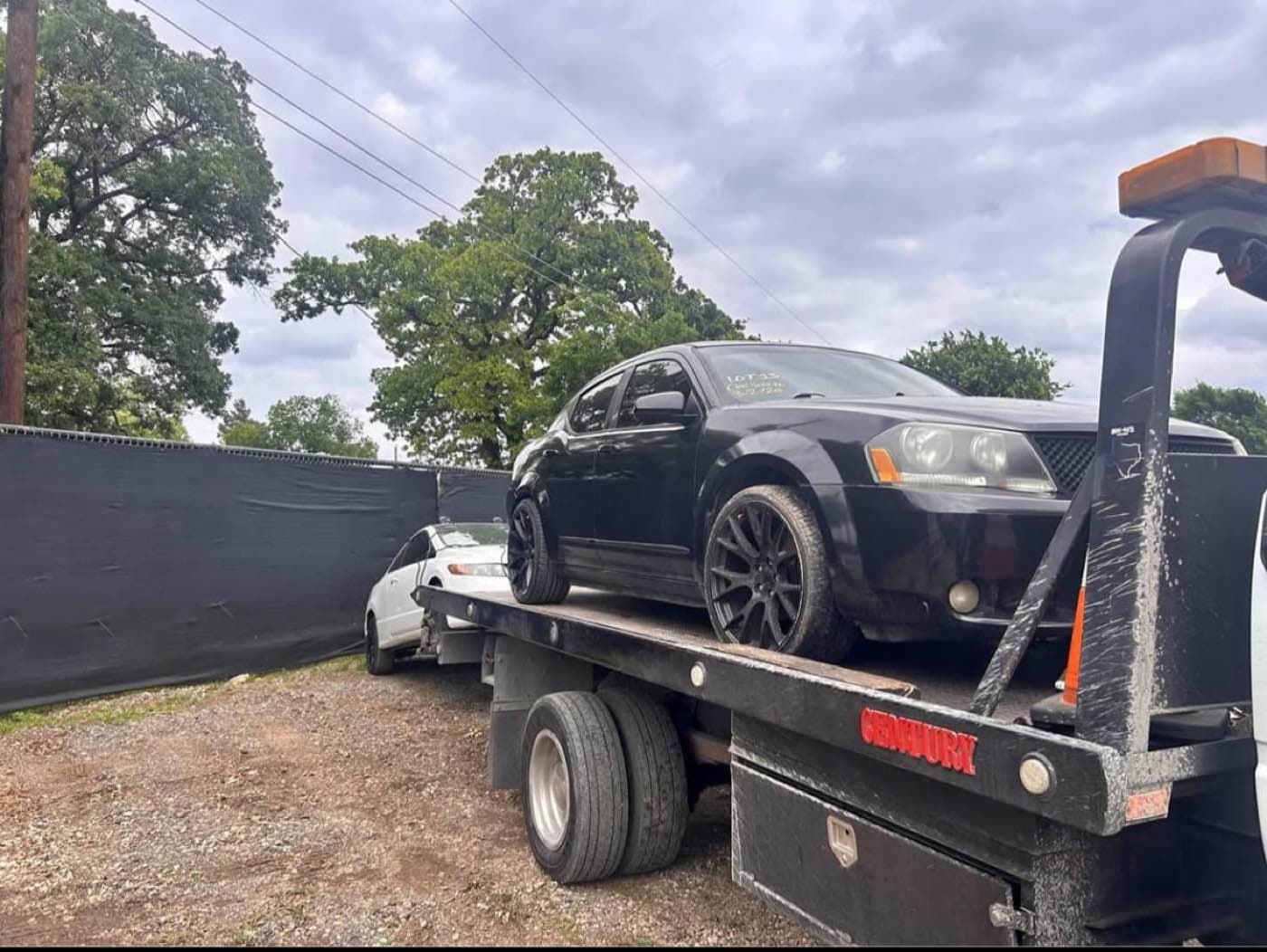 Sedan on the tow truck bed at the lot